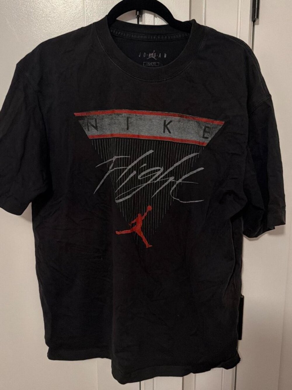 Black Nike Jordan tee with red Jumpman logo and 'NIKE' text